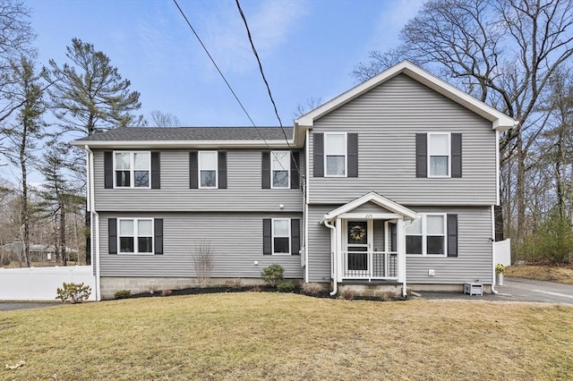 colonial house with a front lawn and fence