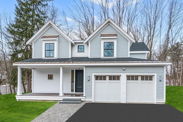 view of front of home with driveway, covered porch, a shingled roof, and a front lawn