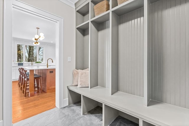 mudroom featuring light wood-style floors and a chandelier