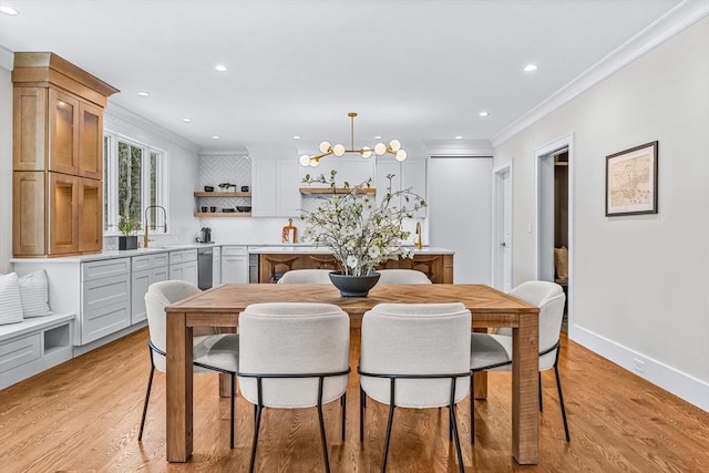 dining area featuring ornamental molding, recessed lighting, a notable chandelier, and light wood-style flooring