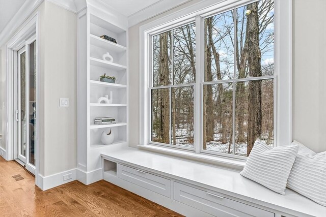 mudroom with light wood-style floors, built in shelves, and baseboards