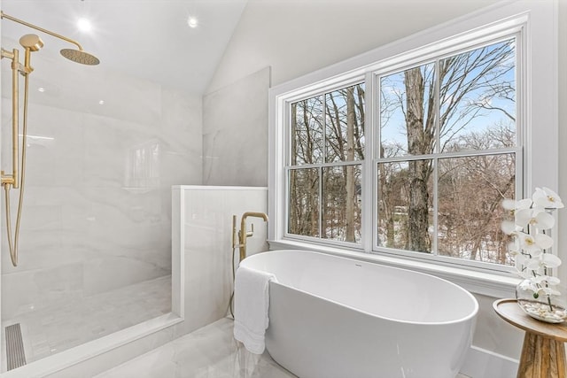 bathroom featuring a soaking tub, a marble finish shower, and vaulted ceiling