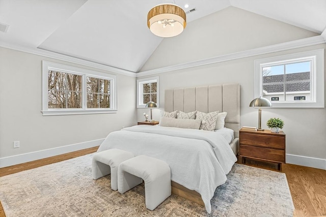 bedroom featuring visible vents, vaulted ceiling, baseboards, and wood finished floors