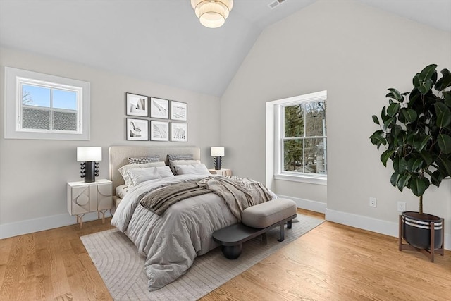 bedroom with high vaulted ceiling, light wood-type flooring, visible vents, and baseboards