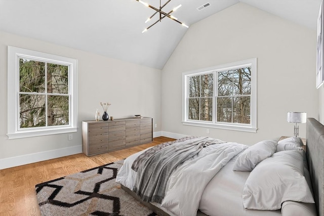 bedroom with visible vents, baseboards, vaulted ceiling, light wood-type flooring, and an inviting chandelier