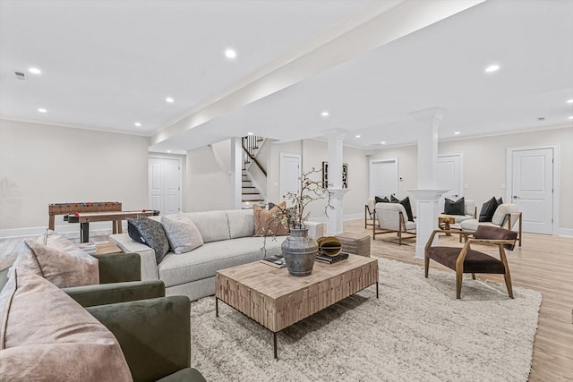 living room with decorative columns, recessed lighting, stairway, ornamental molding, and light wood-type flooring