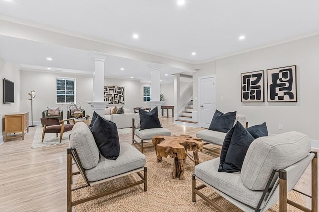 living room with recessed lighting, stairway, light wood-style flooring, ornamental molding, and ornate columns