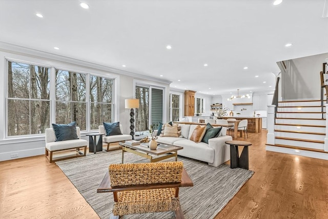 living area with light wood finished floors, stairway, recessed lighting, and crown molding