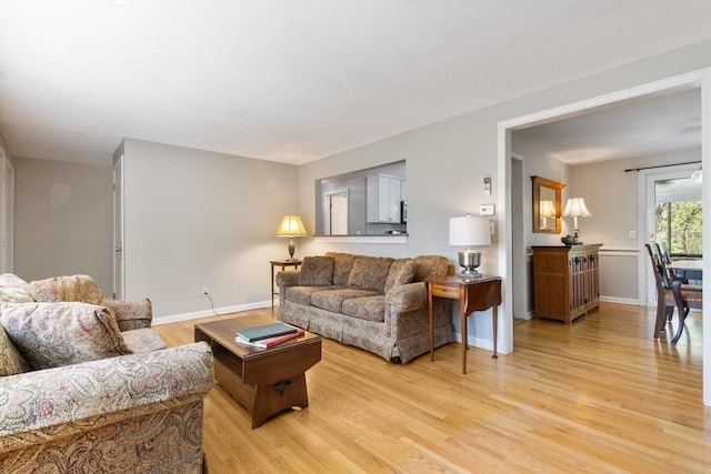living room featuring baseboards and light wood-type flooring