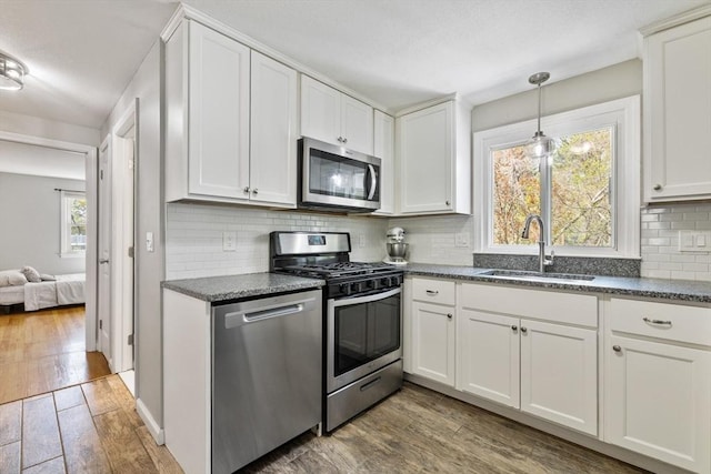kitchen featuring a sink, white cabinetry, appliances with stainless steel finishes, and wood finished floors