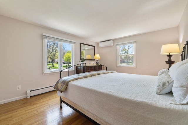 bedroom featuring baseboards, a wall mounted AC, a baseboard heating unit, and wood finished floors