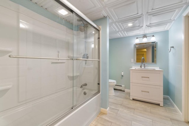 bathroom with baseboard heating, vanity, toilet, baseboards, and bath / shower combo with glass door