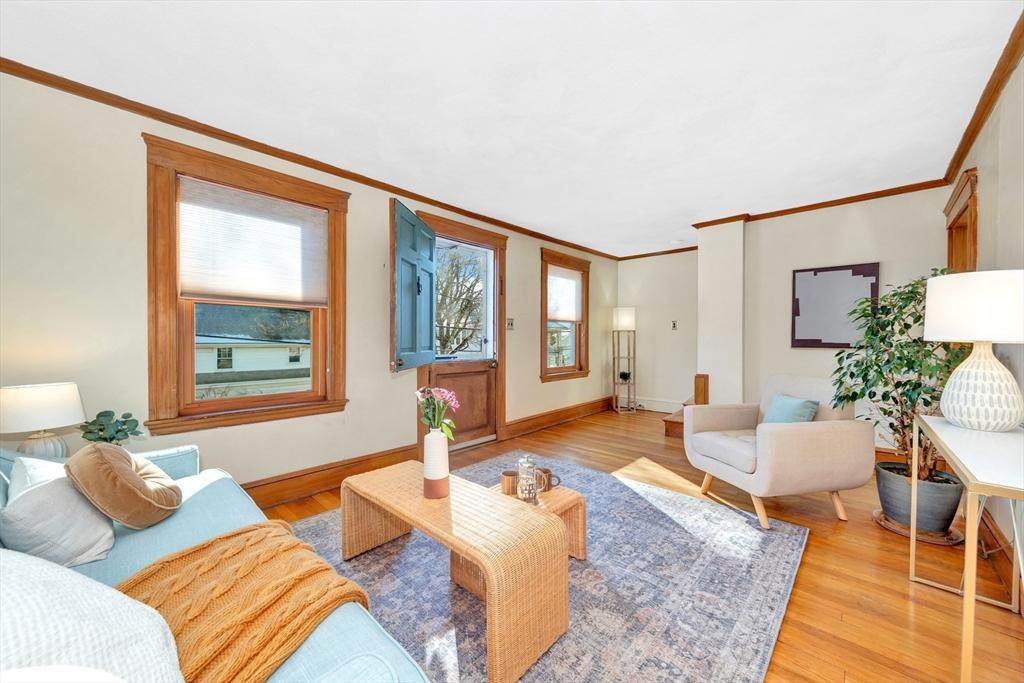 living room featuring light wood-type flooring and crown molding