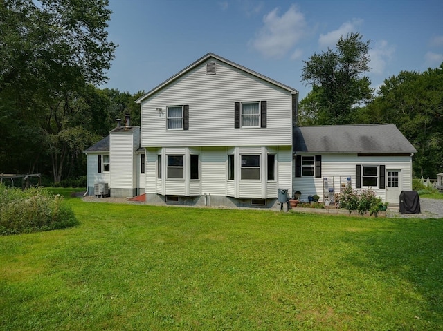 back of property featuring central AC unit and a yard