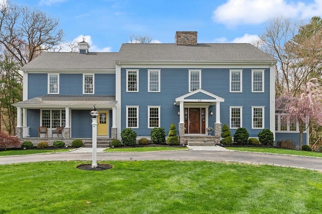 65 Stonegate Dr, East Bridgewater, MA 02333 - colonial inspired home featuring covered porch, a chimney, a front lawn, and stone siding