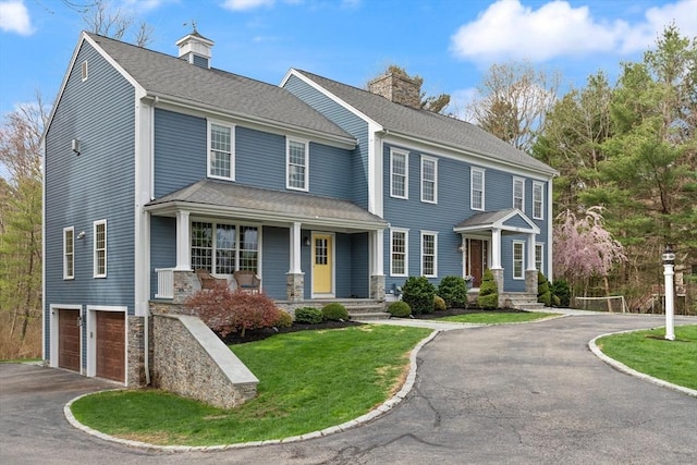 65 Stonegate Dr, East Bridgewater, MA 02333 - view of front facade with aphalt driveway, a garage, a front yard, a chimney, and covered porch