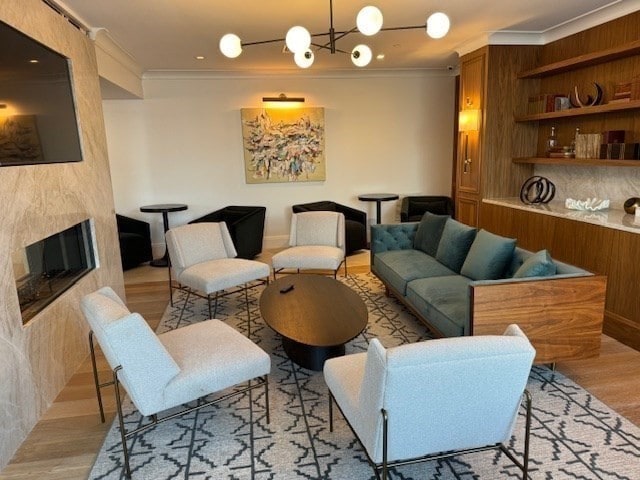 interior space featuring crown molding, light hardwood / wood-style flooring, and a chandelier