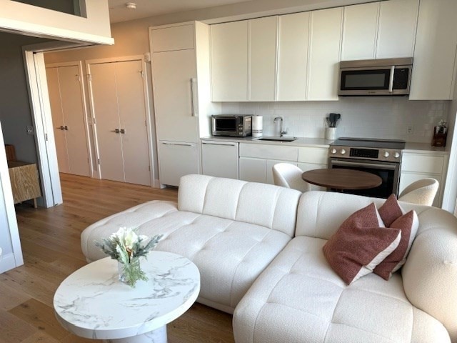 living room featuring hardwood / wood-style floors and sink