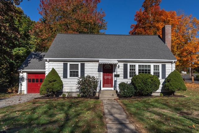 cape cod house featuring a front yard and a garage