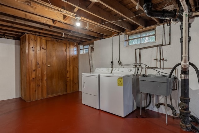 laundry area with washing machine and clothes dryer, sink, and a healthy amount of sunlight