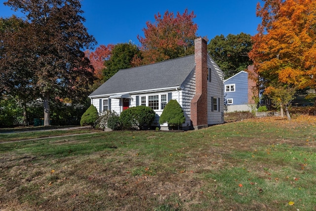 cape cod house with a front yard