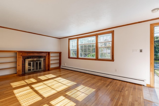 unfurnished living room with a brick fireplace, a wealth of natural light, a baseboard heating unit, and light hardwood / wood-style floors