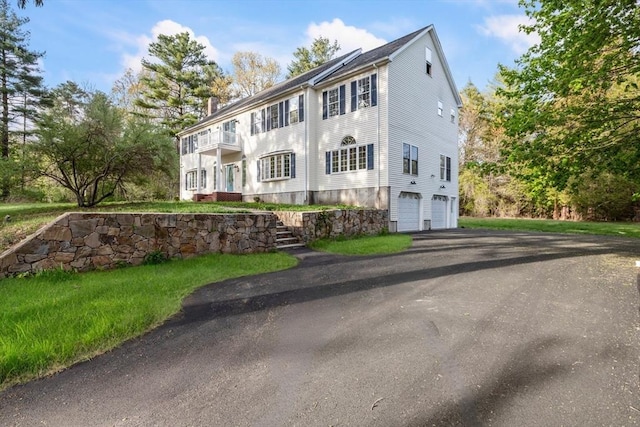 colonial house featuring aphalt driveway and an attached garage