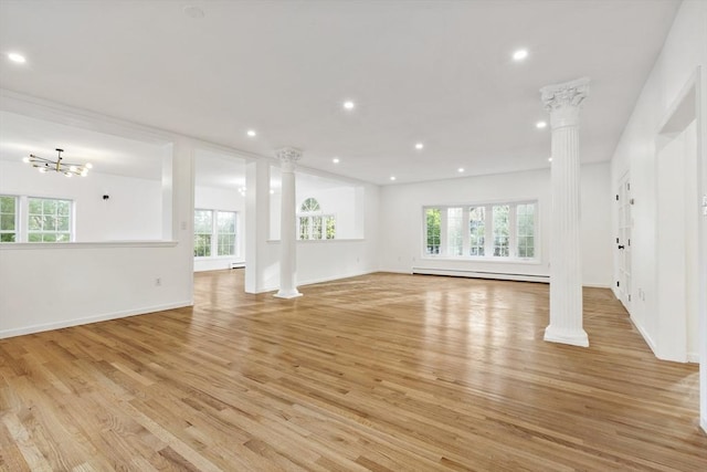 unfurnished living room with light wood finished floors, plenty of natural light, ornate columns, and recessed lighting