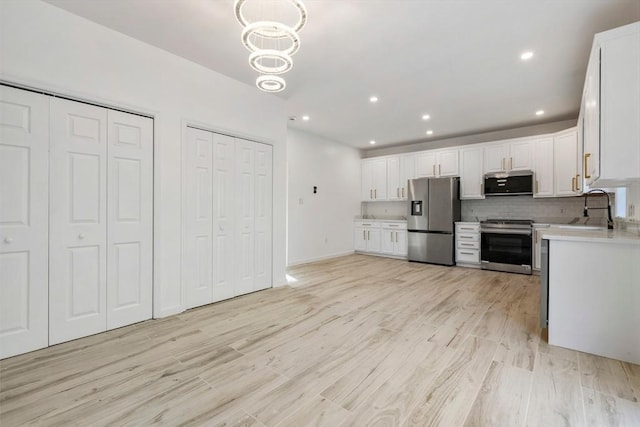 kitchen featuring light countertops, appliances with stainless steel finishes, light wood-style flooring, and a sink
