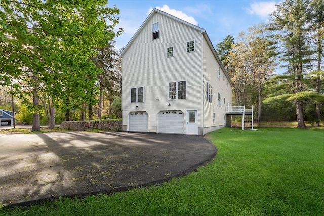 view of property exterior with a lawn, driveway, and a garage