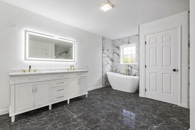 full bath featuring a sink, a soaking tub, double vanity, and marble finish floor
