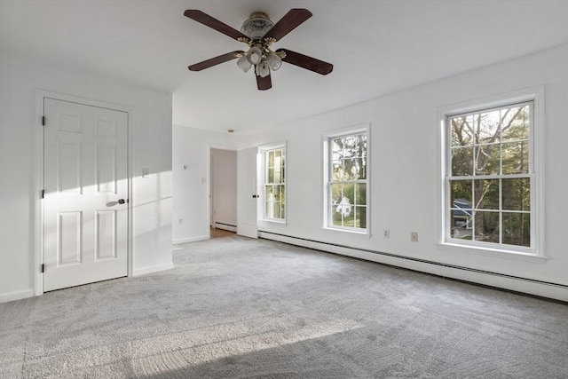 carpeted spare room featuring baseboards, a ceiling fan, and a baseboard heating unit