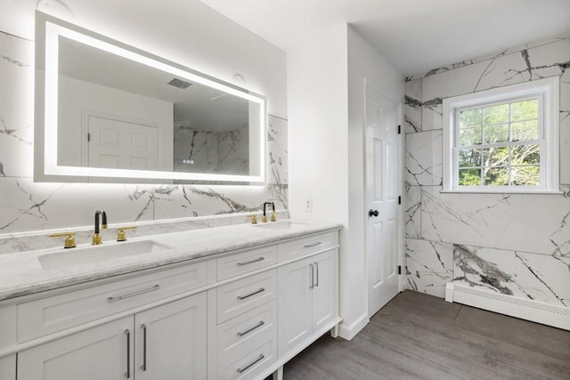 bathroom with a sink, double vanity, and wood finished floors