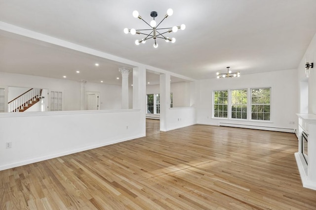 unfurnished living room featuring light wood-style floors, stairway, baseboard heating, and a notable chandelier