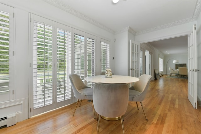 dining area with baseboard heating, french doors, crown molding, and light hardwood / wood-style flooring