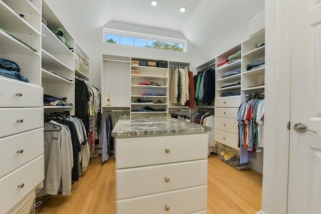 walk in closet with light wood-type flooring and vaulted ceiling