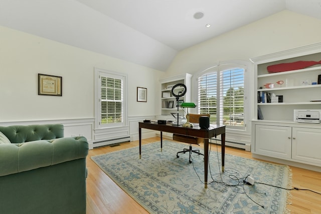 office space featuring a baseboard heating unit, built in features, lofted ceiling, and light hardwood / wood-style floors