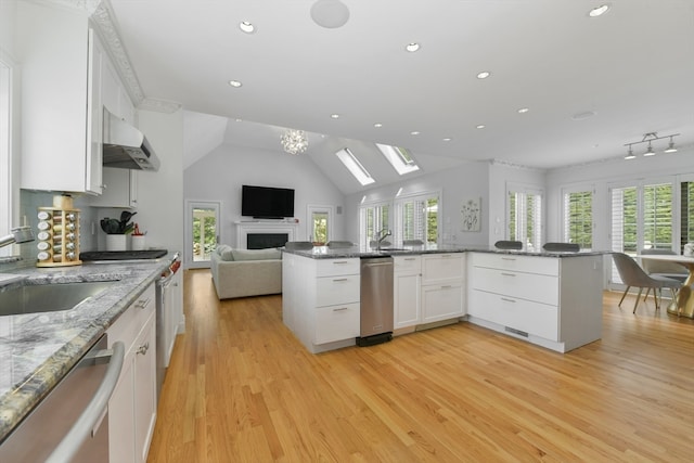 kitchen featuring light hardwood / wood-style flooring, white cabinetry, kitchen peninsula, and stainless steel dishwasher