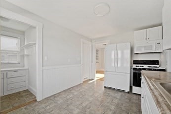 kitchen featuring white cabinets and white appliances