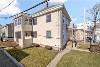 view of front of property with a balcony and a front lawn