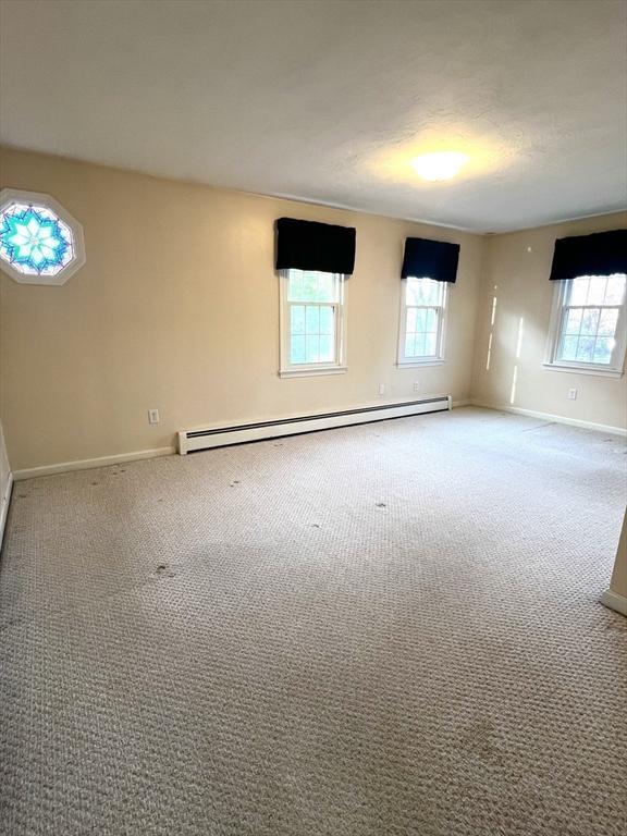 7 Glen Ave, Millbury, MA 01527 - empty room with baseboards, plenty of natural light, a baseboard heating unit, and carpet floors