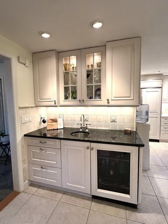 7 Glen Ave, Millbury, MA 01527 - bar with a sink, indoor wet bar, decorative backsplash, light tile patterned floors, and wine cooler