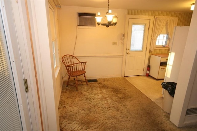 interior space with visible vents, a notable chandelier, and a wall unit AC