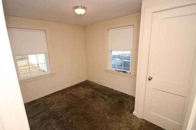 unfurnished room featuring a wealth of natural light and baseboards