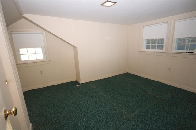 spare room with baseboards and dark carpet