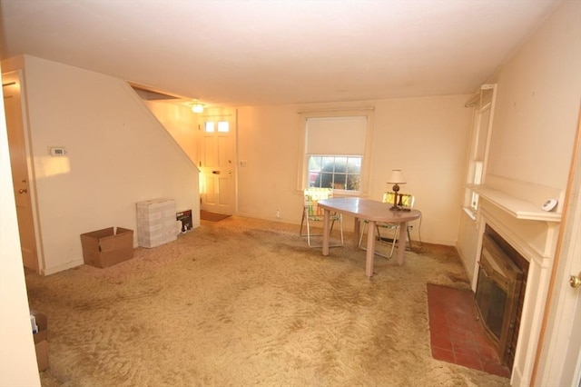 dining space featuring a glass covered fireplace and carpet floors