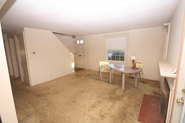 carpeted dining room with stairway