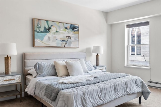 bedroom with carpet floors and a baseboard heating unit