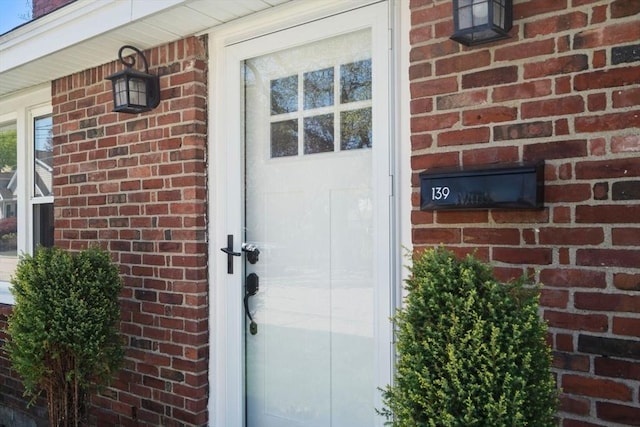 entrance to property featuring brick siding