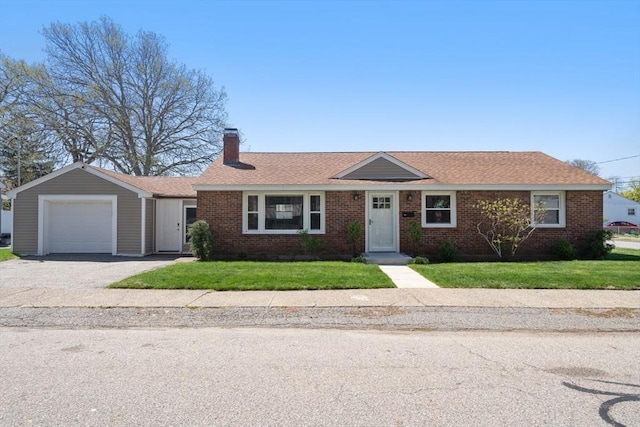 single story home featuring an attached garage, a chimney, a front lawn, and brick siding